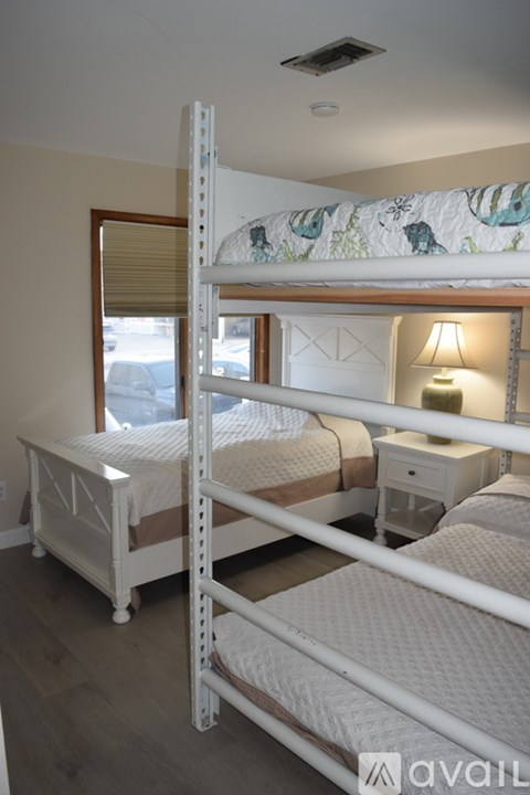 A bedroom with two beds and a window.