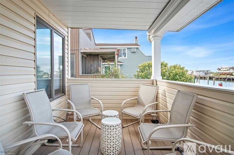 A balcony with chairs and a table is shown.