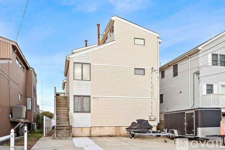 A two-story beige house with a garage in front.