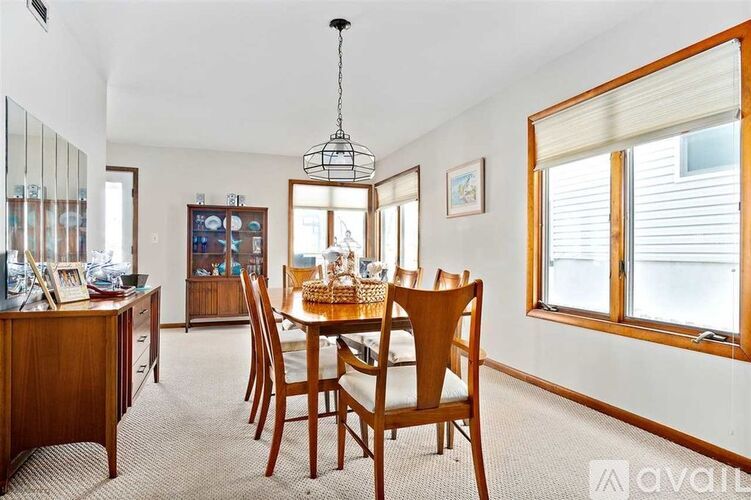 A dining room with a wooden table and chairs.