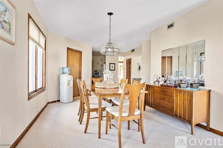 A dining room with a wooden table and chairs.