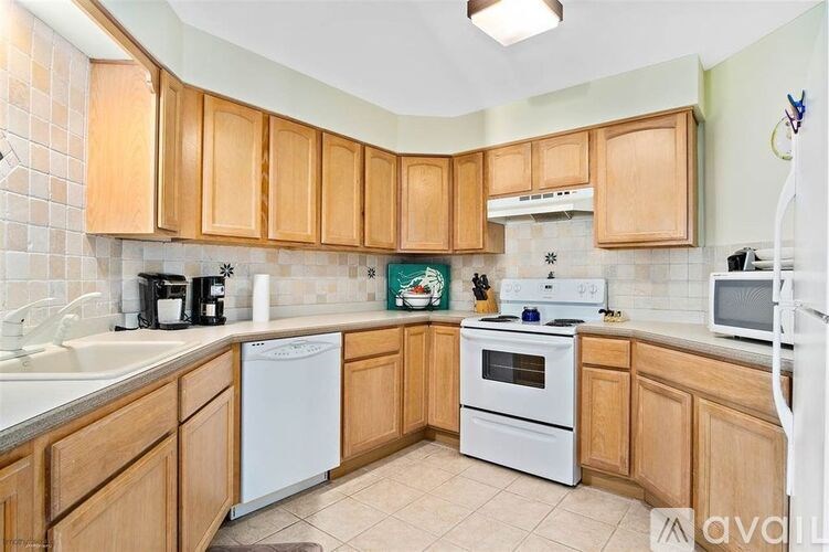 A kitchen with wooden cabinets and white appliances.