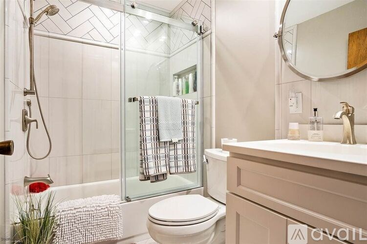 A bathroom with a toilet, sink, and shower.