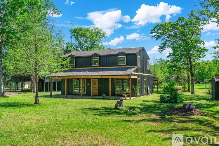 A house with a green lawn and trees around it.