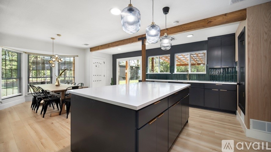A modern kitchen with a large island and wooden floors.