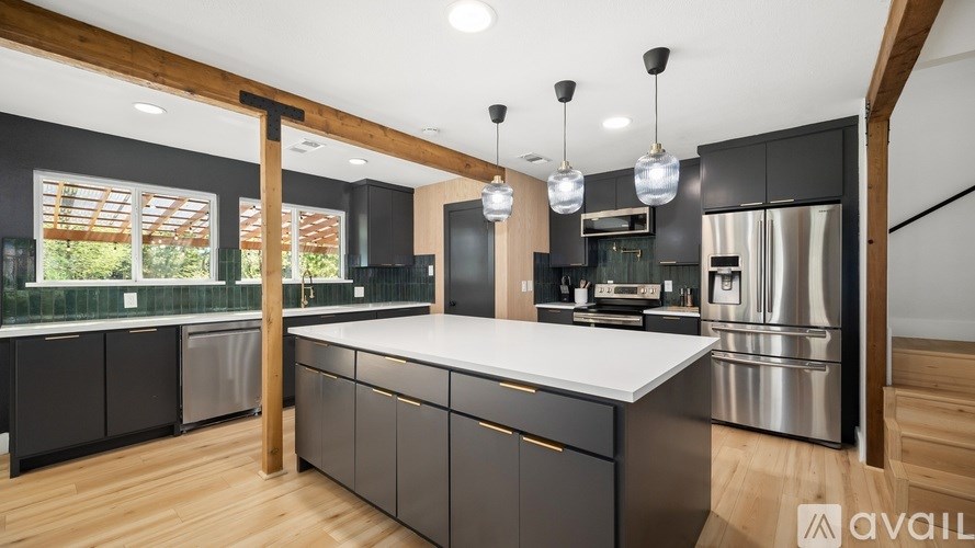 A modern kitchen with a large island and stainless steel appliances.