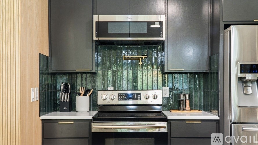 A modern kitchen with a stove top oven and a microwave above it.
