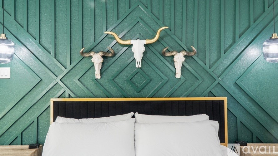 A bed with white pillows and a black headboard with a gold trim.