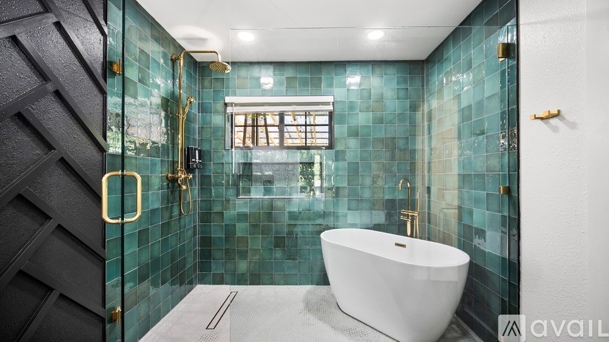 A modern bathroom with a white bathtub and gold fixtures.