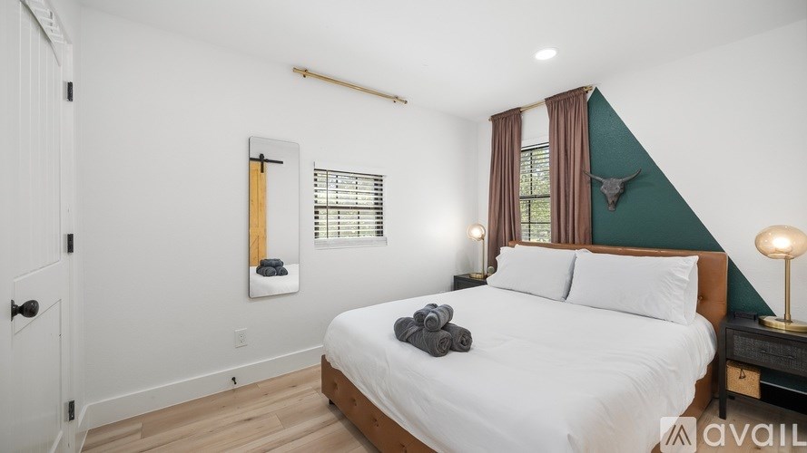 A bedroom with a bed, nightstand, and window.