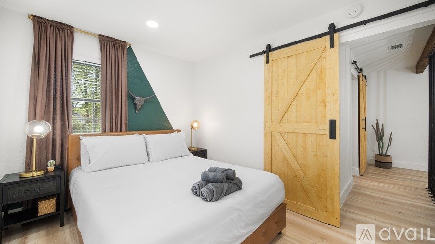 A bedroom with a bed, nightstands, and a sliding door.