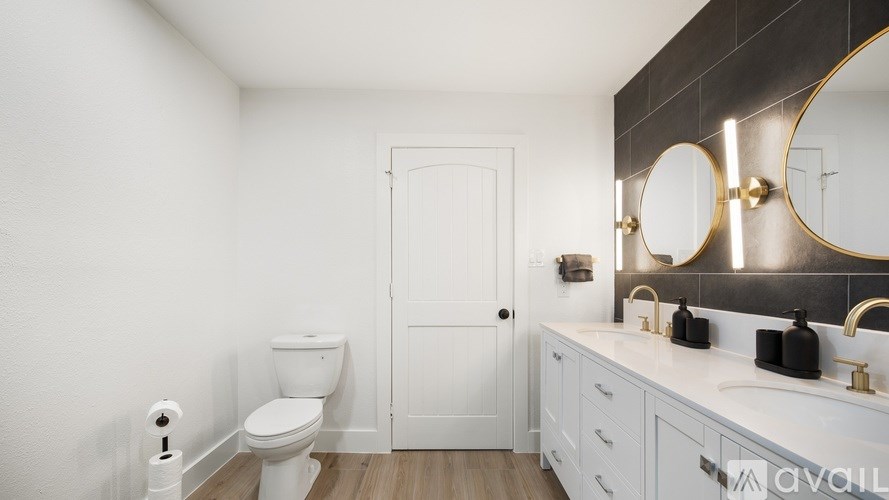 A bathroom with a toilet, sink, and mirror.