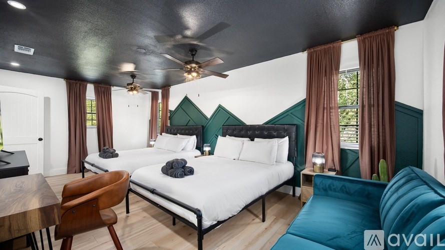 A bedroom with a large bed and a ceiling fan.