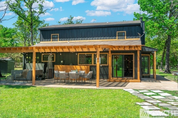 A modern house with a wooden deck and glass doors.