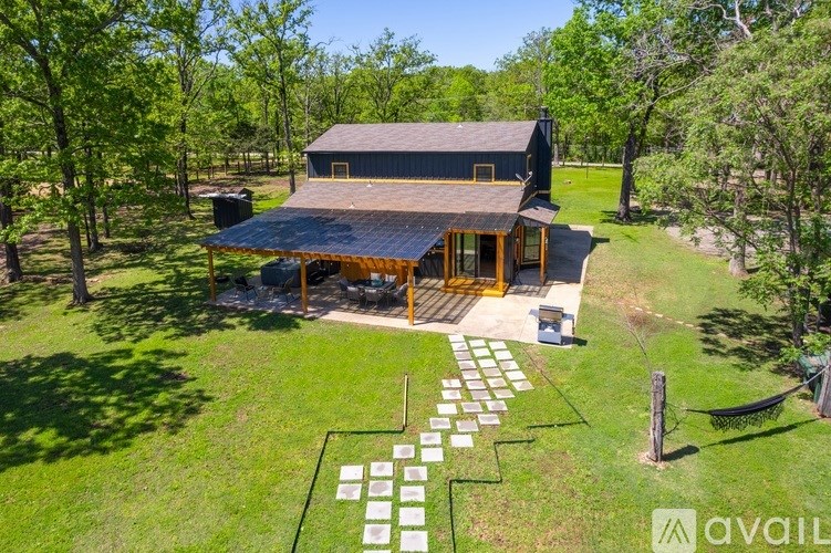A house with a large lawn and trees surrounding it.