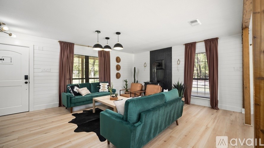 A living room with a green couch and a white wall.