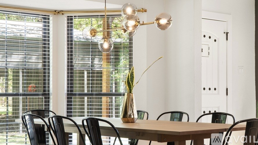 A dining room with a table, chairs, and a chandelier.