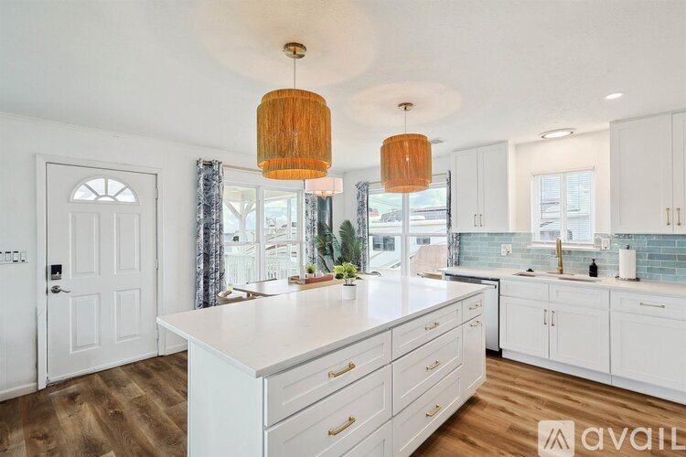 A kitchen with white cabinets and a large island.