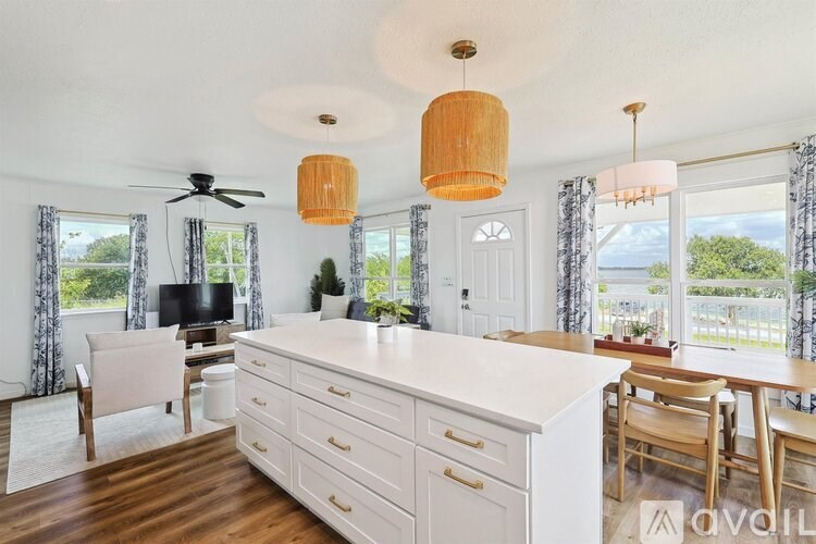 A kitchen with a white countertop and wooden floors.
