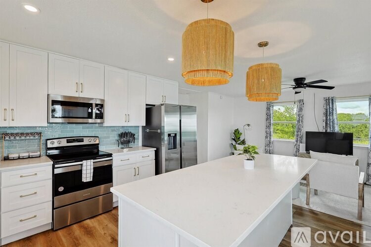 A modern kitchen with a large island and stainless steel appliances.
