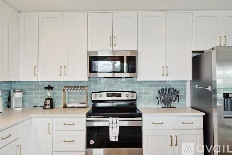 A kitchen with white cabinets and a black stove top.