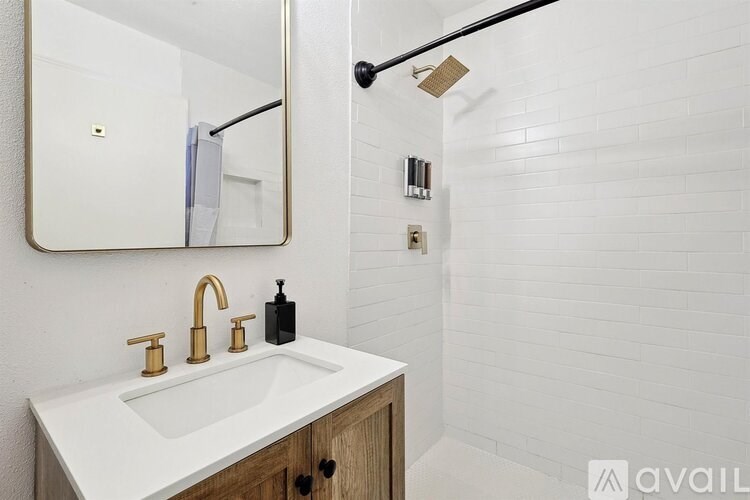 A bathroom with a white sink and a mirror above it.