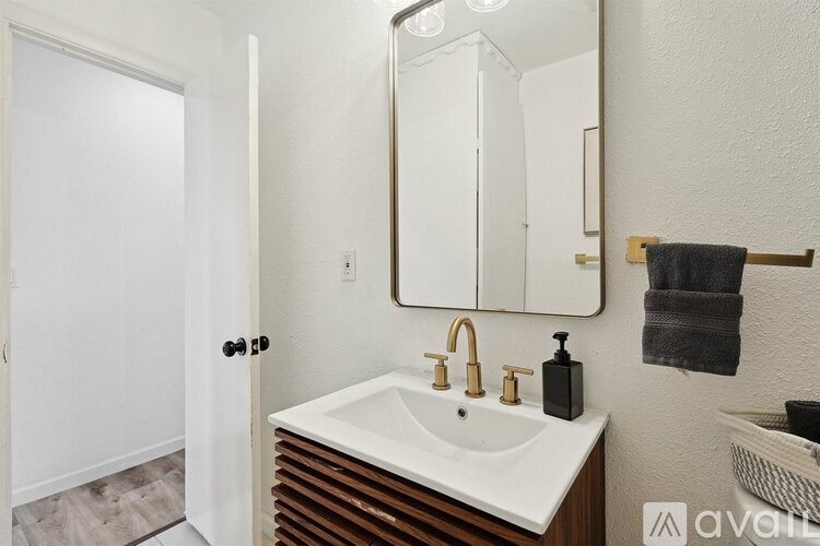 A bathroom with a white sink and a mirror above it.