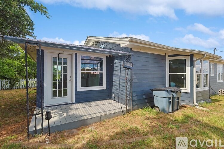 A blue house with a white door and windows is for sale.