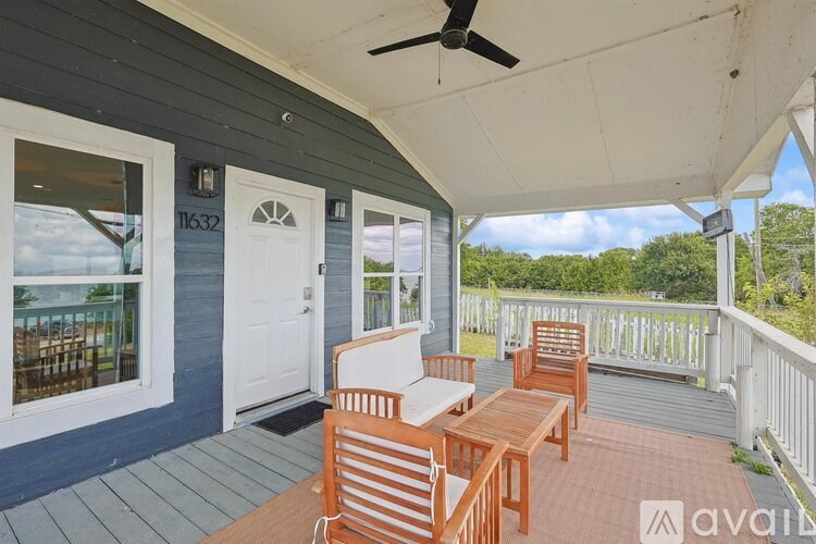 A wooden table and chairs are set up on a porch.