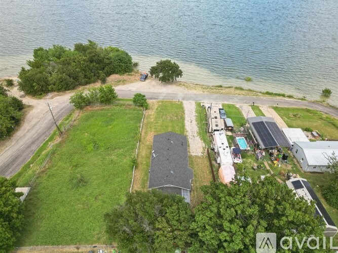 A bird's eye view of a property with a house, a swimming pool, and a car parked on the driveway.