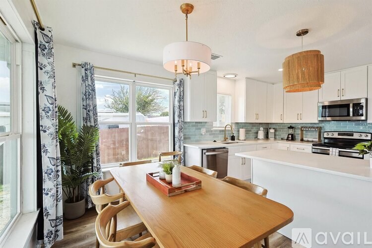 A kitchen with a table and chairs in front of a window.