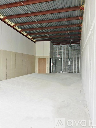 A large empty room with a metal roof and white walls.
