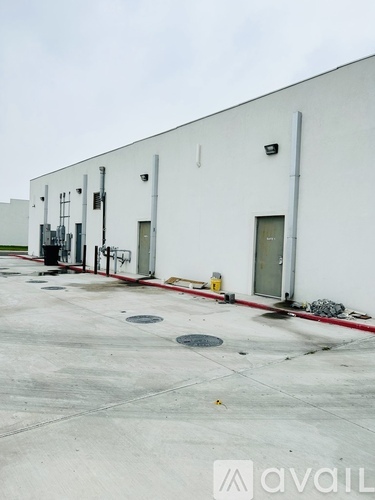 A white industrial building with a red line on the ground.