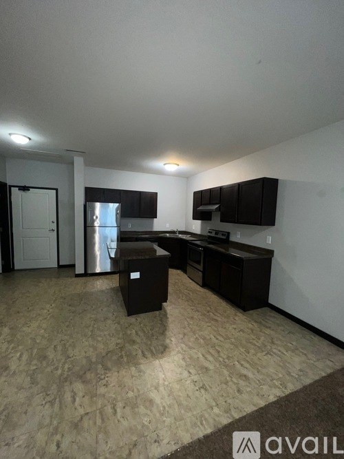 A kitchen with black cabinets and a countertop with a sink.
