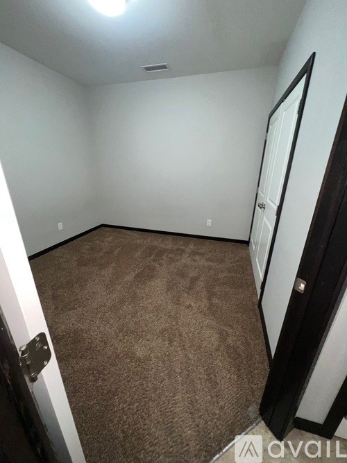 A room with brown carpet and white walls.