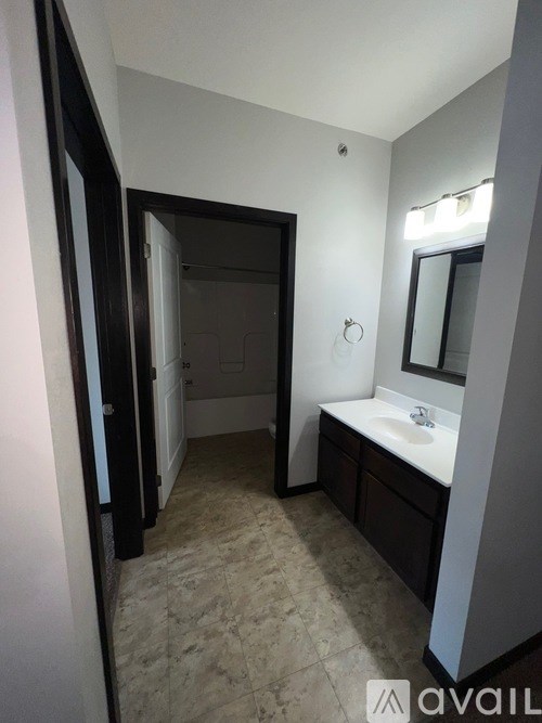A bathroom with a sink, mirror, and a towel rack.
