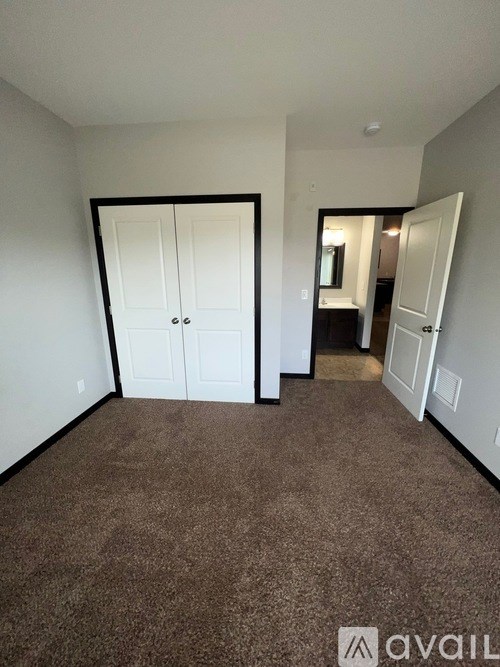 A room with a carpeted floor and a white door.