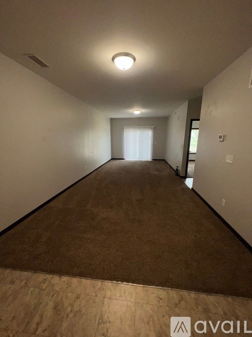 A long hallway with a carpeted floor and white walls.