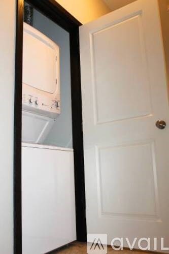 A white door is open to a small kitchen with a white oven.