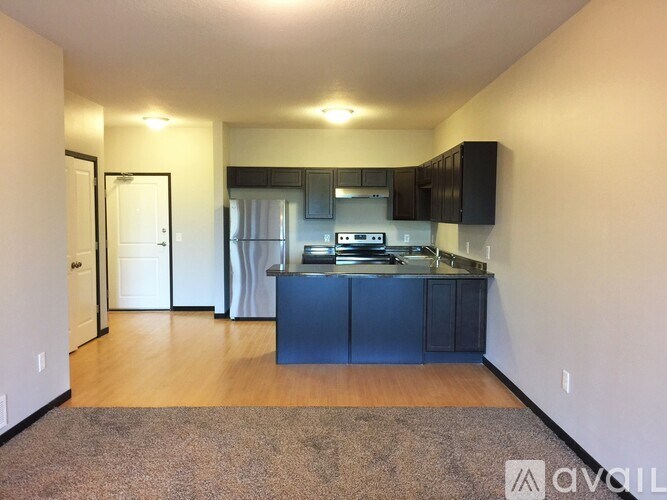 A kitchen with a blue island and black cabinets.
