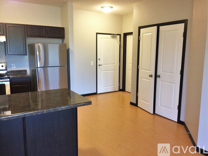A kitchen with dark wood cabinets and a granite countertop.