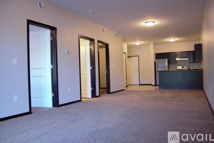 A spacious room with a kitchen area in the background.