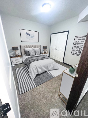 A bedroom with a bed, nightstand, and a picture on the wall.