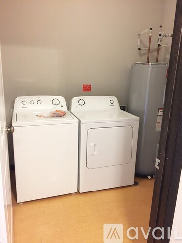 Two white front loading washing machines in a laundry room.