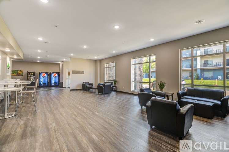 A spacious waiting area with black leather chairs and a wooden floor.