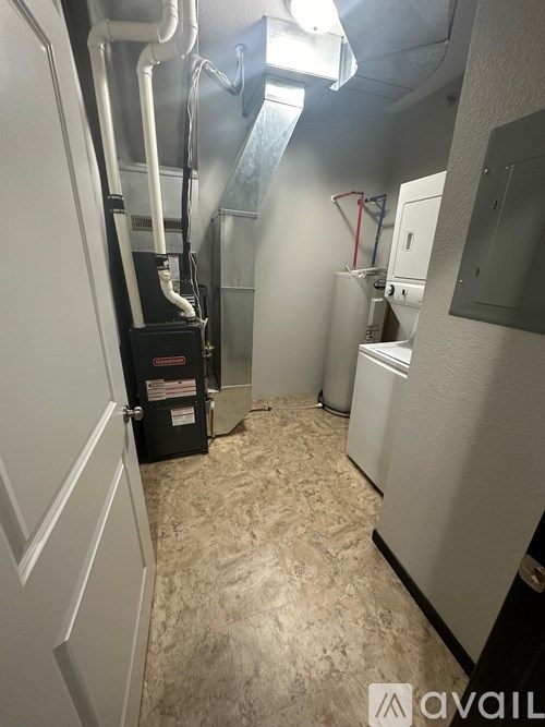 A small, white, and beige room with a refrigerator and a cabinet.
