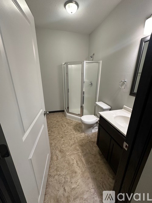 A bathroom with a toilet, sink, and shower.