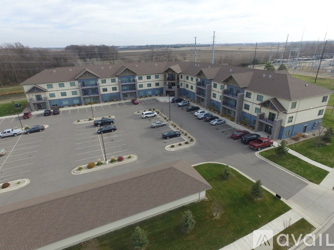 A parking lot in front of a building with a blue and white facade.