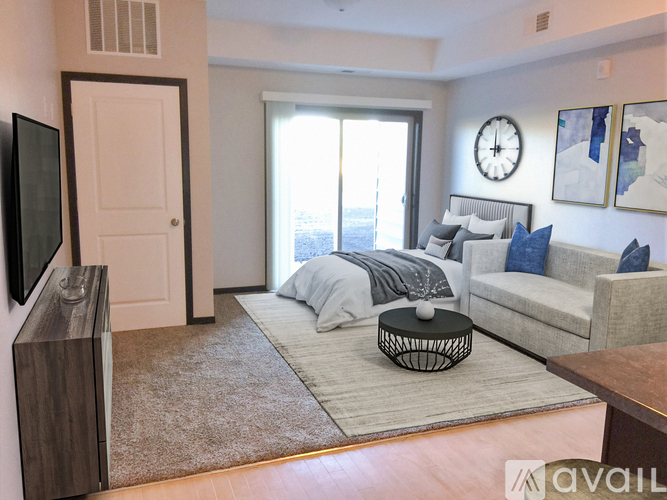 A living room with a grey couch and a large window.