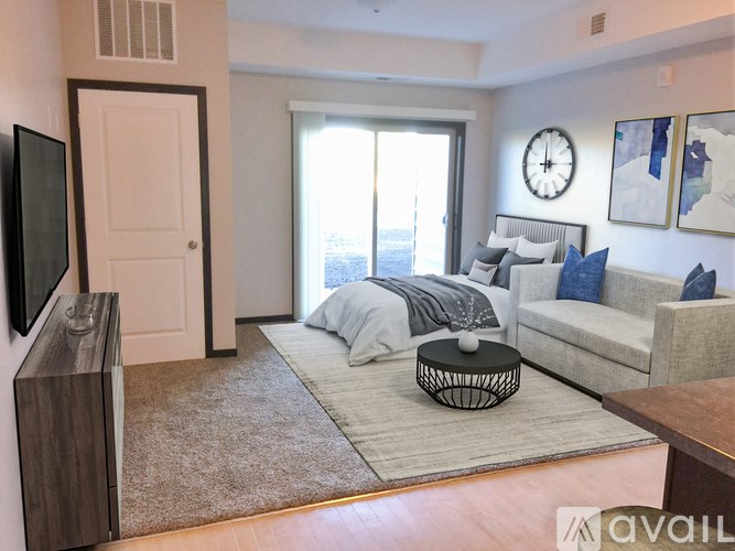 A living room with a grey couch and a large window.